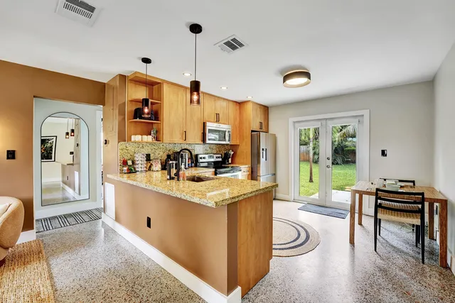 a living room with stainless steel appliances granite countertop furniture and a view of kitchen