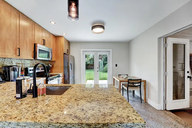 a view of a kitchen with dining area a sink wooden floor and a living room