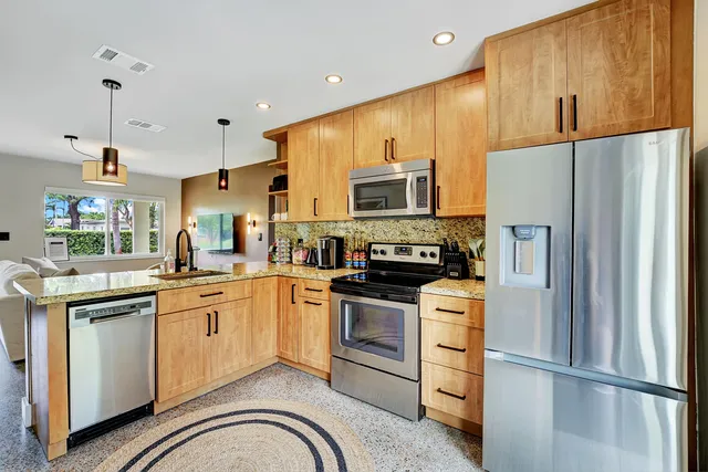 a kitchen with stainless steel appliances a refrigerator sink and microwave