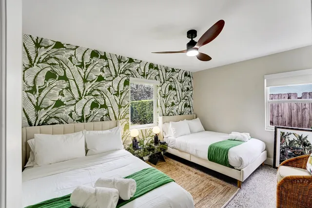 a bedroom with a bed lamp and a potted plant