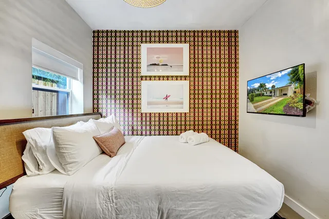 a bedroom with a bed and a wall painting