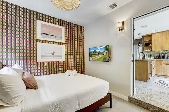 a bedroom with a bed and a painting on the wall