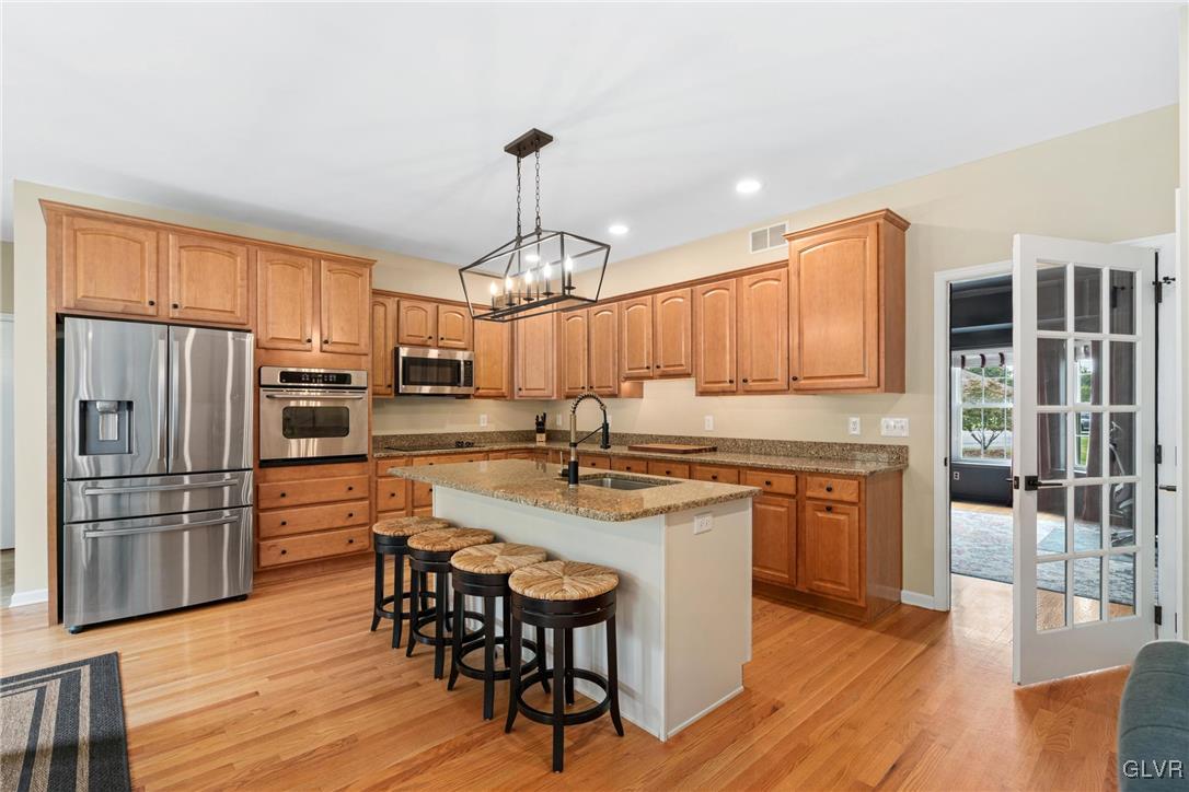 211 Bushkill Ridge Road Wind Gap, PA 18091 - Photo 9 of 30 a kitchen with stainless steel appliances granite countertop a stove refrigerator a sink dishwasher a dining table and chairs with wooden floor