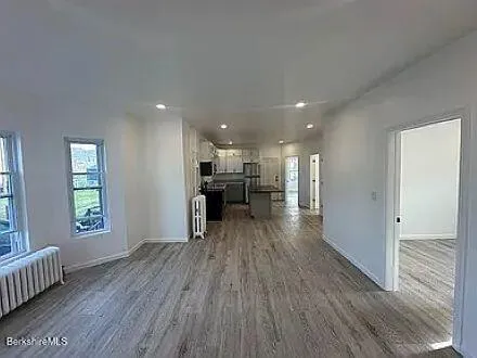 a view of empty room with wooden floor