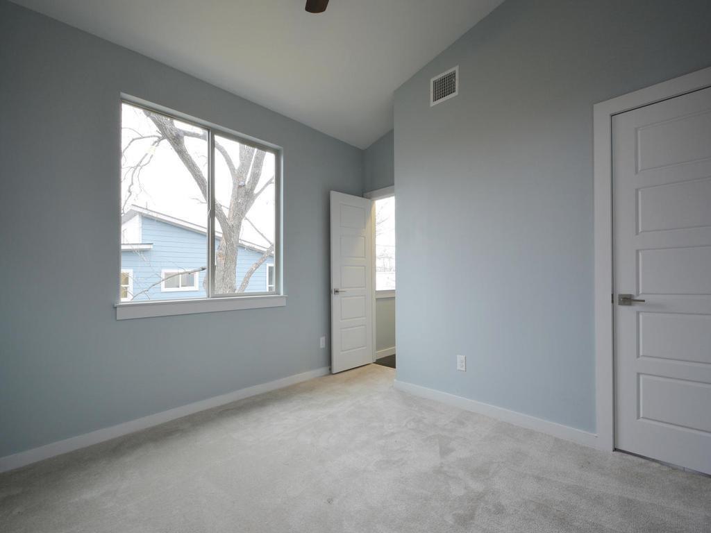 1608 Miriam Avenue, Unit B Austin, TX 78702 - Photo 6 of 10 Unfurnished bedroom featuring lofted ceiling, light colored carpet, and a ceiling fan