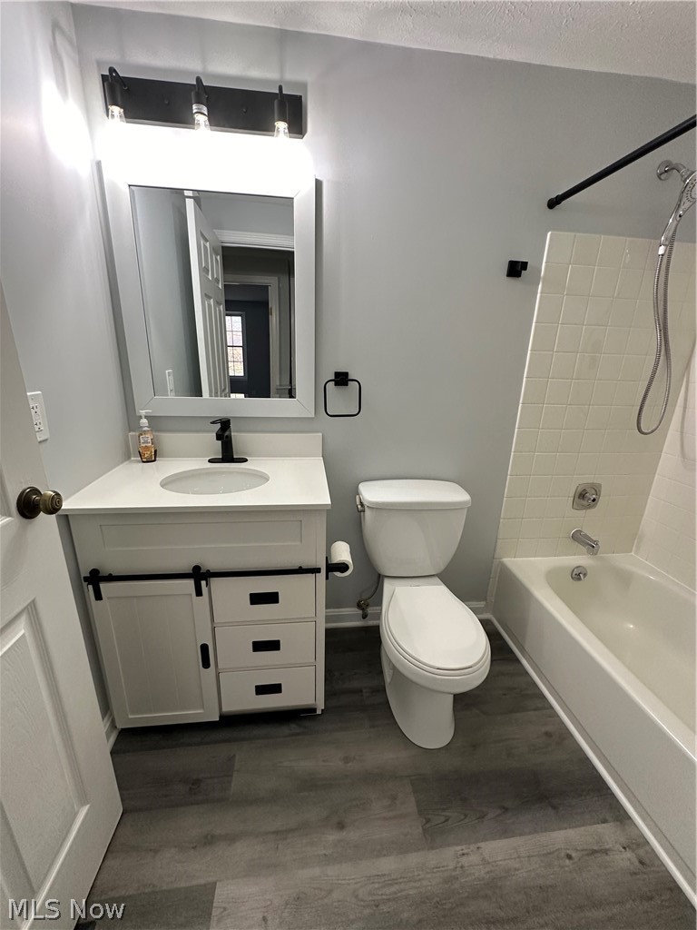 16213 Drake Road Strongsville, OH 44136 - Photo 19 of 28 Full bathroom featuring hardwood / wood-style flooring, tiled shower / bath combo, a textured ceiling, and large vanity