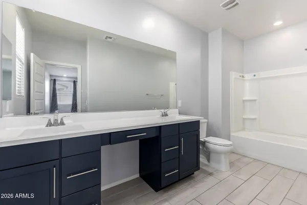 a bathroom with a double vanity sink toilet mirror and bathtub