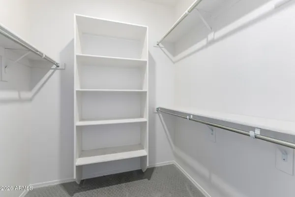 a view of walk in closet with empty racks
