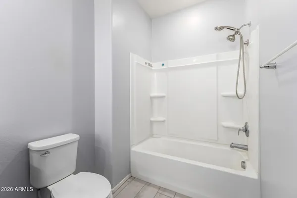 a white bath tub sitting next to a white toilet and a shower