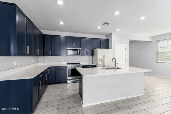a kitchen with kitchen island granite countertop a sink stove and refrigerator
