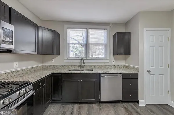 a kitchen with stainless steel appliances granite countertop a sink stove and cabinets