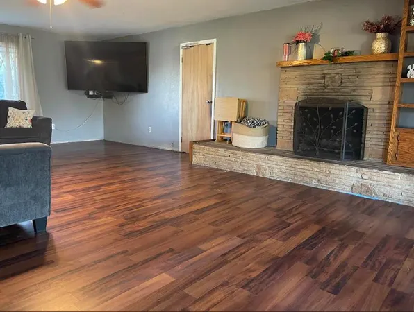 a view of a livingroom with wooden floor and a fireplace