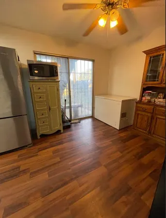 a view of a kitchen with wooden floor and electronic appliances