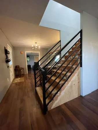 a view of a hallway with wooden floor and staircase