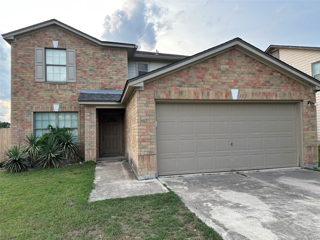 a front view of a house with a yard and garage