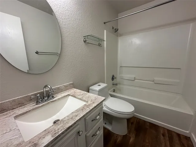an empty room with chandelier fan and windows