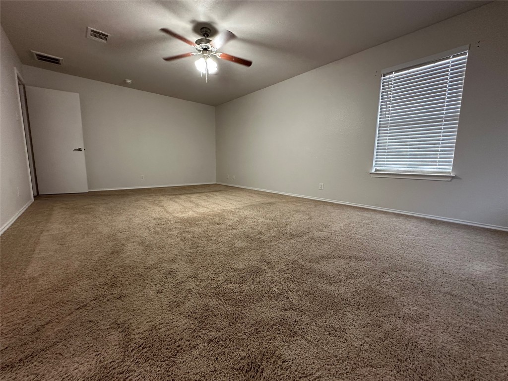 113 Lex Word Kyle, TX 78640 - Photo 28 of 40 an empty room with a window and a ceiling fan