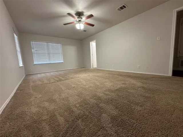 an empty room with a ceiling fan and a window