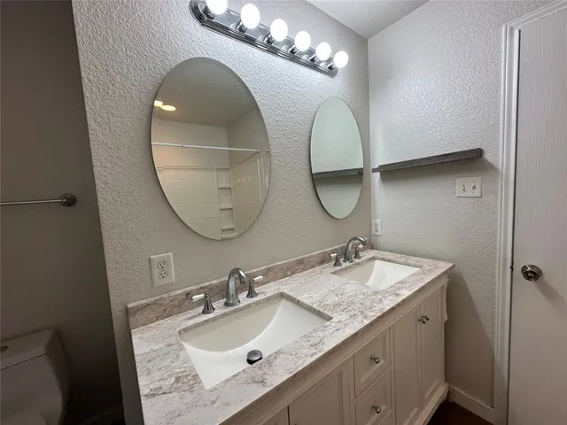 a en suite bathroom with a double vanity sink and a mirror