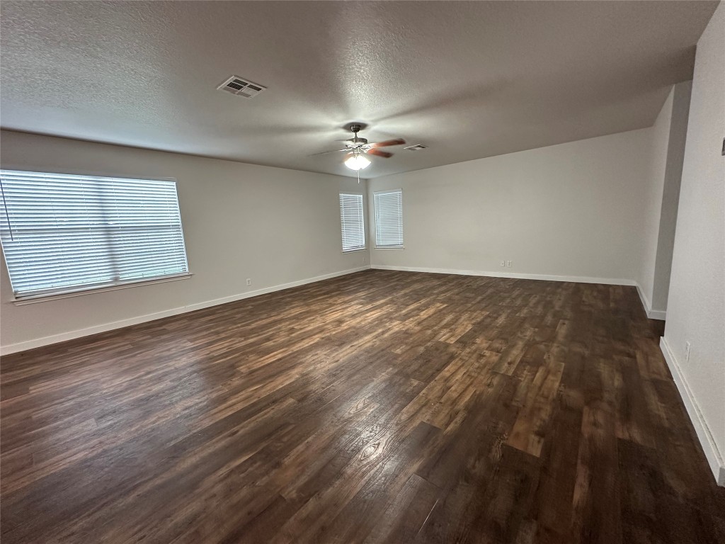 113 Lex Word Kyle, TX 78640 - Photo 4 of 40 an empty room with wooden floor ceiling fan and windows