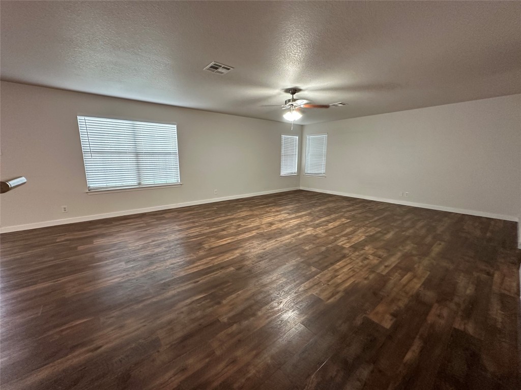113 Lex Word Kyle, TX 78640 - Photo 5 of 40 an empty room with wooden floor ceiling fan and windows