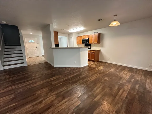 a kitchen that has a lot of cabinets in it and wooden floors