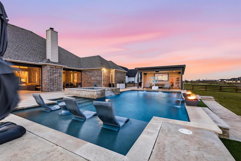 7751 Faught Road Northlake, TX 76226 - Photo 2 of 39 Expansive backyard retreat featuring a swimming pool with integrated seating, an elevated spa, and a dedicated pool house with an outdoor screen