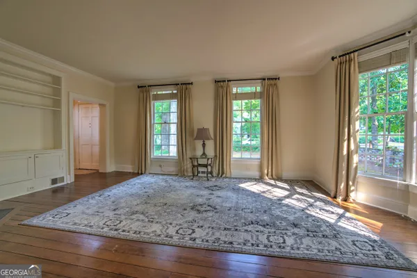 a bedroom with a bed windows and a walk in closet