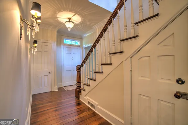 a view of a room that has wooden floor and windows