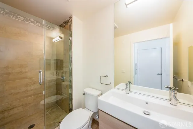 a bathroom with a sink mirror toilet and shower