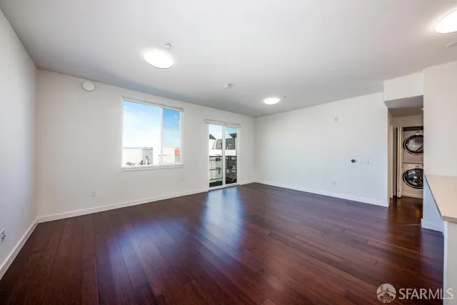 a view of empty room with wooden floor and window