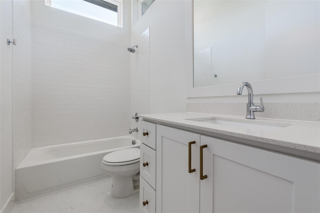 4718 Bryan Street, Unit 301 Dallas, TX 75204 - Photo 12 of 12 a bathroom with a granite countertop sink a toilet and shower
