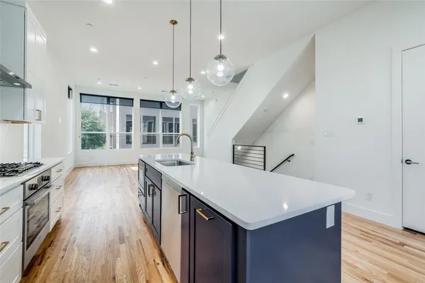 a kitchen with a stove and a wooden floor
