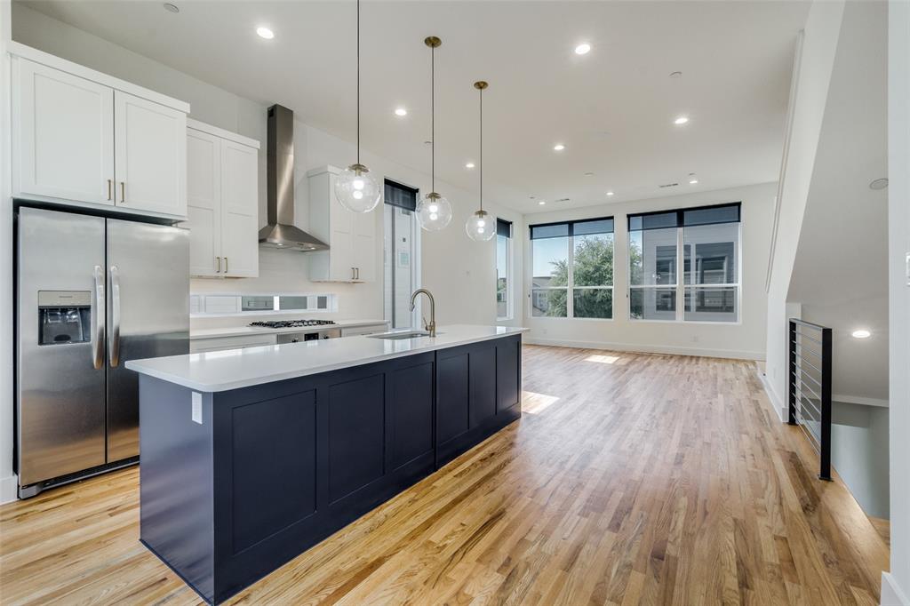 4718 Bryan Street, Unit 301 Dallas, TX 75204 - Photo 6 of 12 a kitchen with kitchen island wooden floors appliances and cabinets