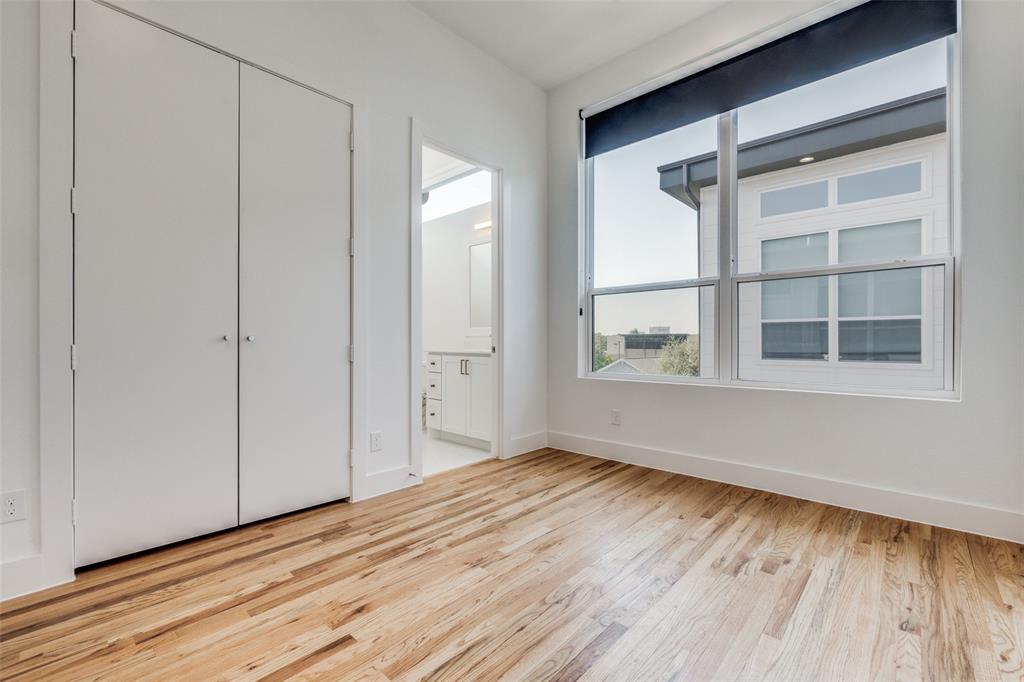 4718 Bryan Street, Unit 301 Dallas, TX 75204 - Photo 10 of 12 a view of an empty room with wooden floor and a window