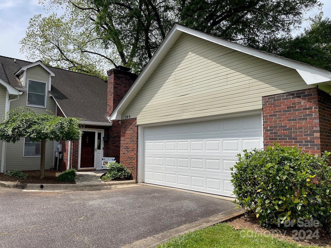 a front view of house with yard and trees in the background