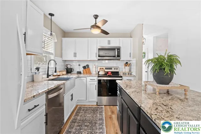 a kitchen with kitchen island granite countertop a sink stainless steel appliances and cabinets