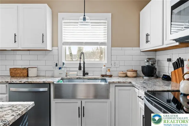 a kitchen with stainless steel appliances granite countertop a sink stove and cabinets