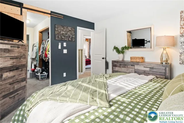 a bedroom with a bed and flat screen tv