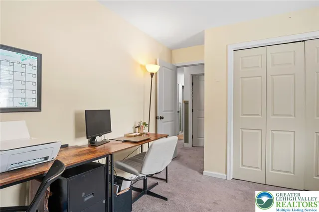 a view of a workspace with furniture and a window