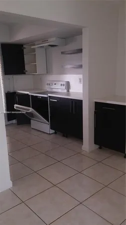 a kitchen with a stove top oven and cabinets