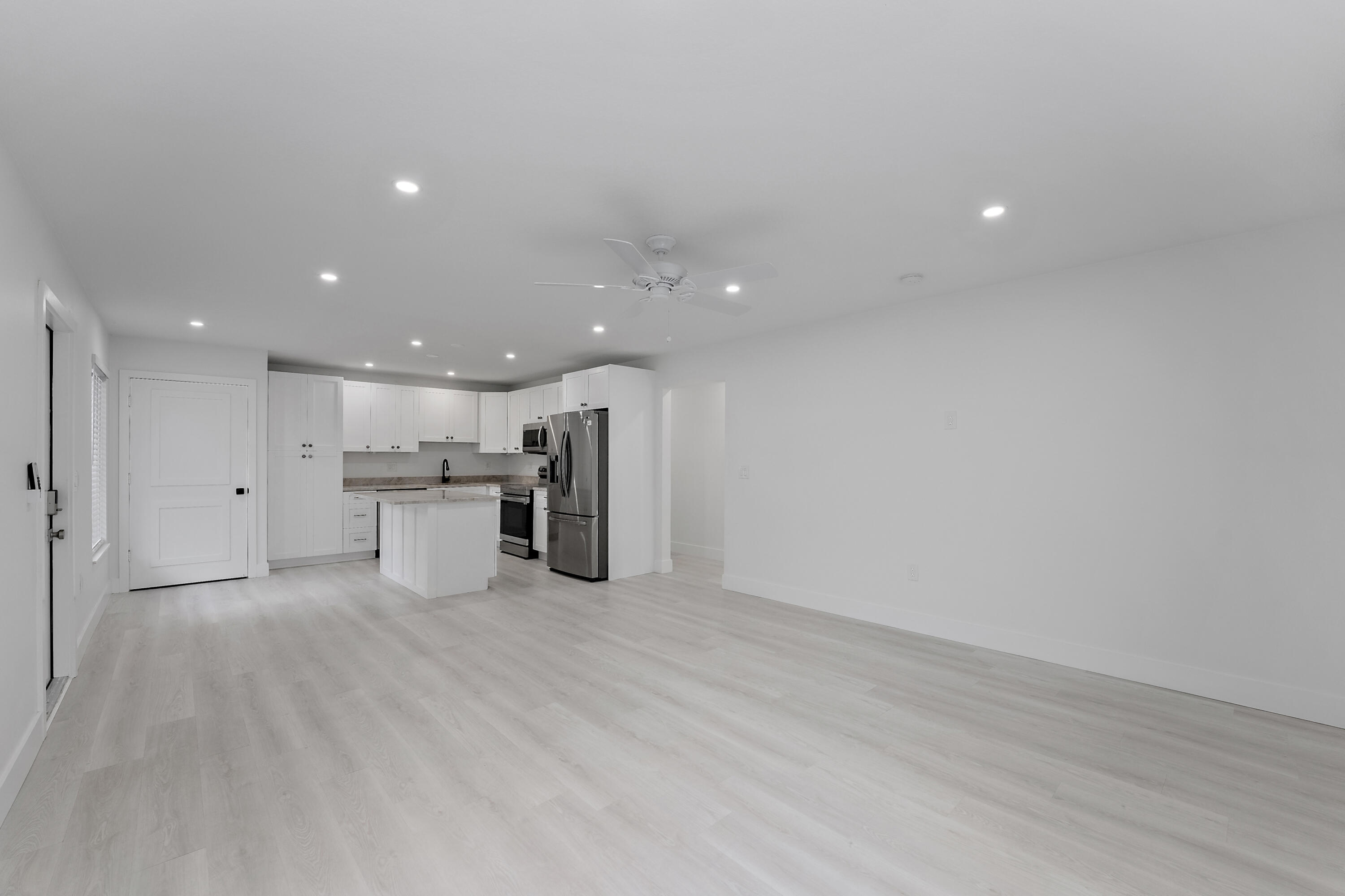 1279 Beach Road, Unit 3 Singer Island, FL 33404 - Photo 5 of 23 a view of kitchen with refrigerator stove and wooden floor