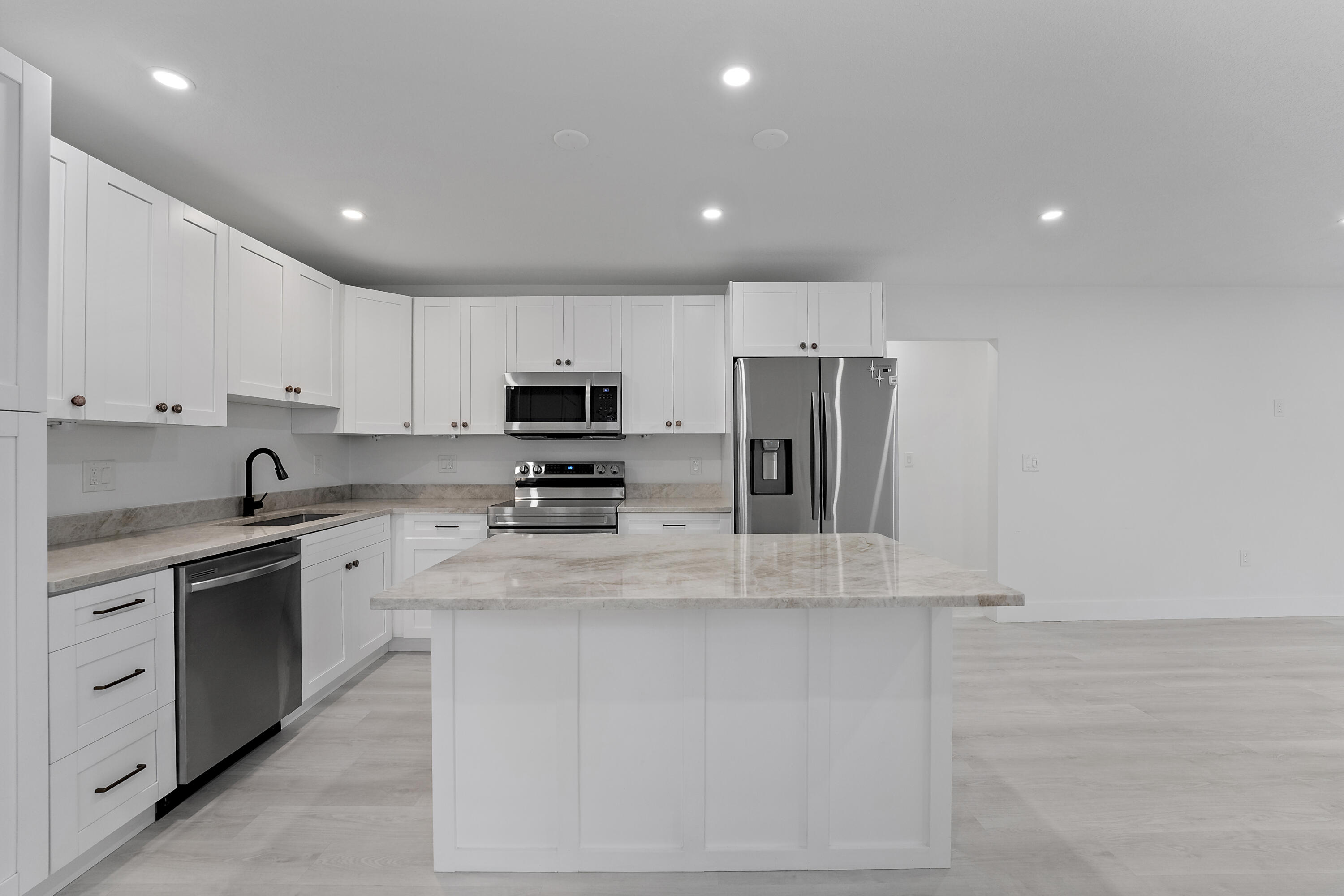 1279 Beach Road, Unit 3 Singer Island, FL 33404 - Photo 8 of 23 a kitchen with stainless steel appliances granite countertop a sink a stove a refrigerator and white cabinets