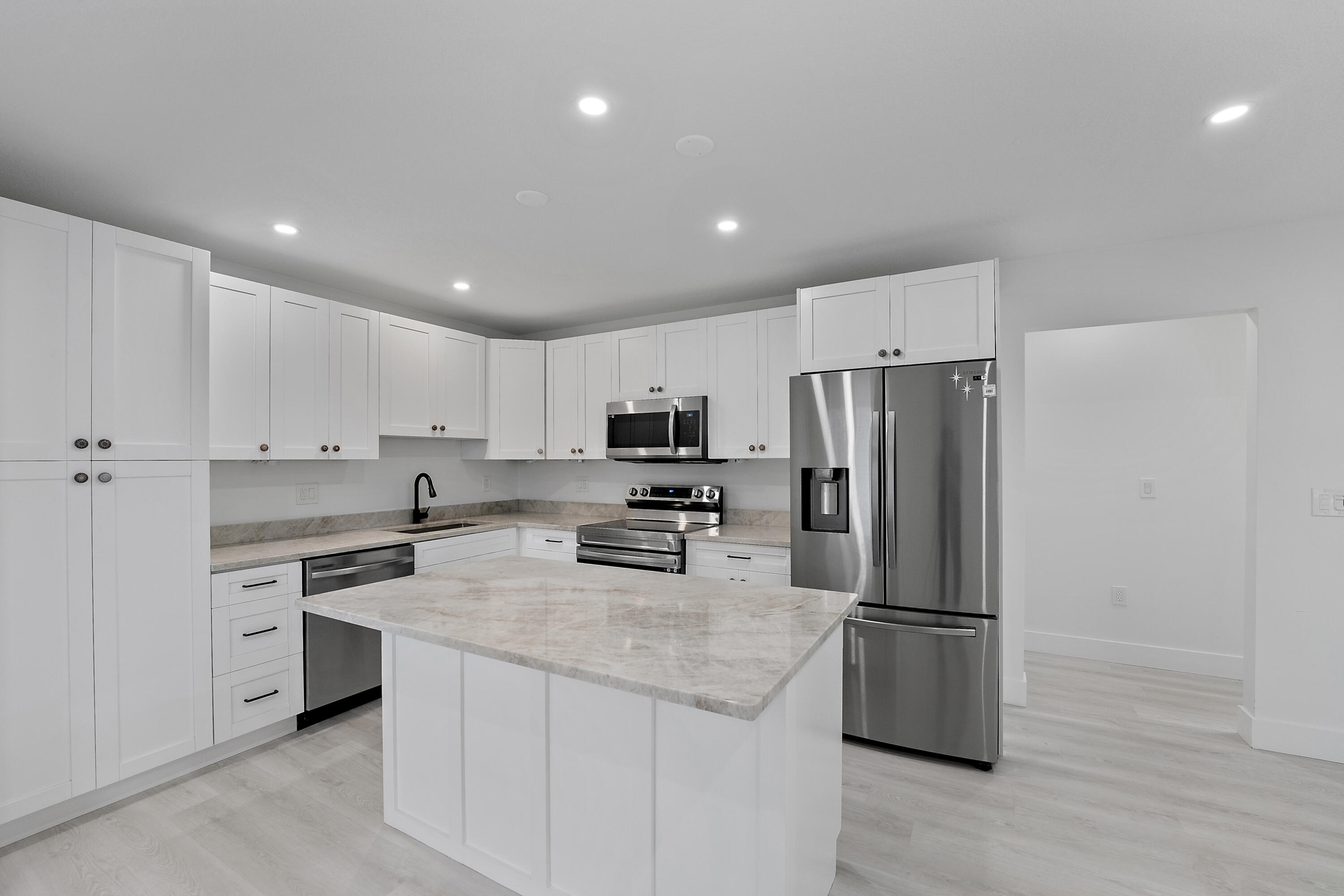1279 Beach Road, Unit 3 Singer Island, FL 33404 - Photo 9 of 23 a kitchen with stainless steel appliances a refrigerator sink and microwave