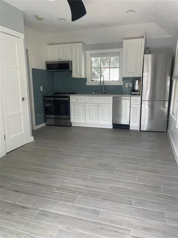 a kitchen with stainless steel appliances a refrigerator and a stove top oven