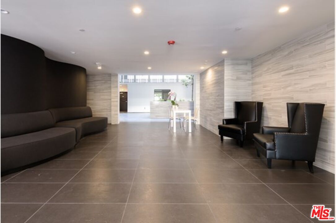 129 South Kings Road, Unit PH5 Los Angeles, CA 90048 - Photo 13 of 14 a living room with furniture and a flat screen tv