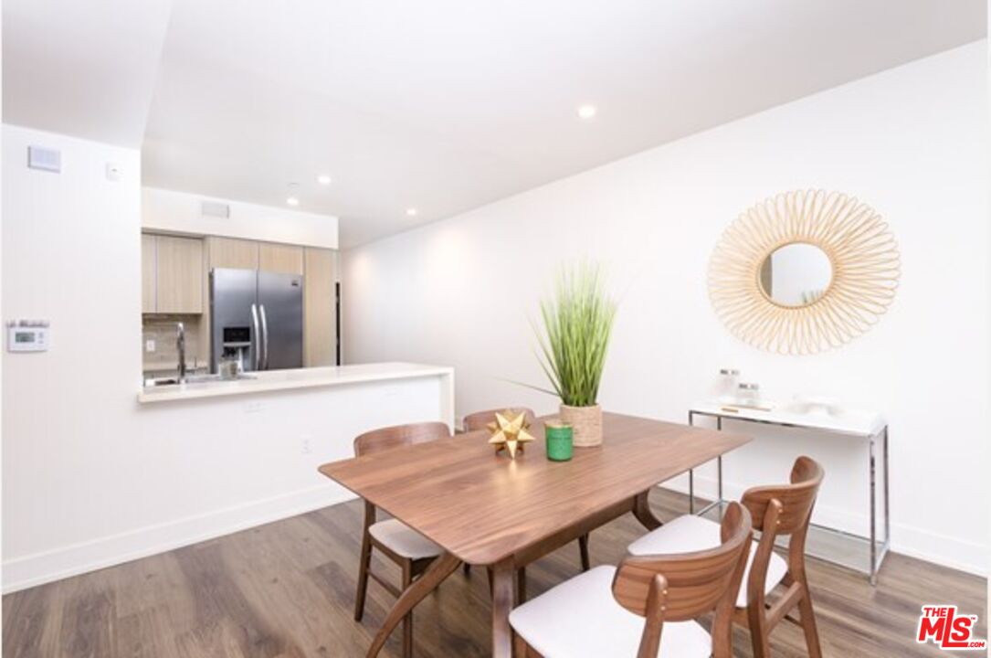 129 South Kings Road, Unit PH5 Los Angeles, CA 90048 - Photo 3 of 14 a view of a dining room with furniture and wooden floor