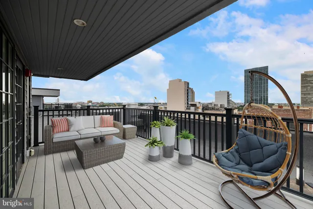a roof deck with couch and garden view