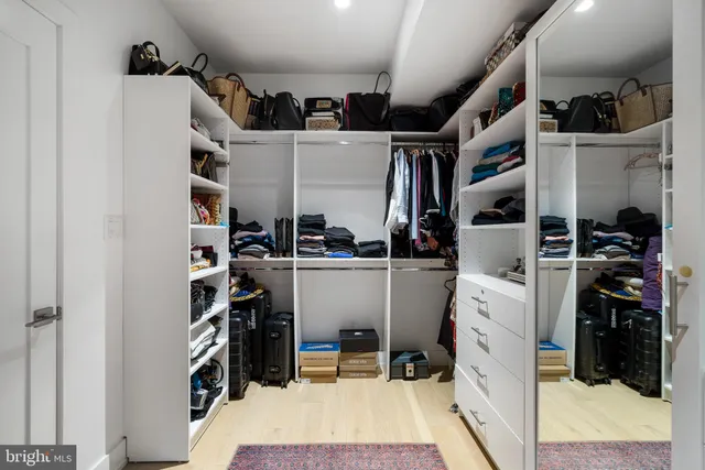 a view of walk in closet with clothes and shoes