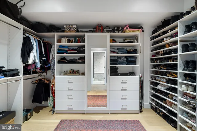 a bedroom with a bed and potted plants with wooden floor